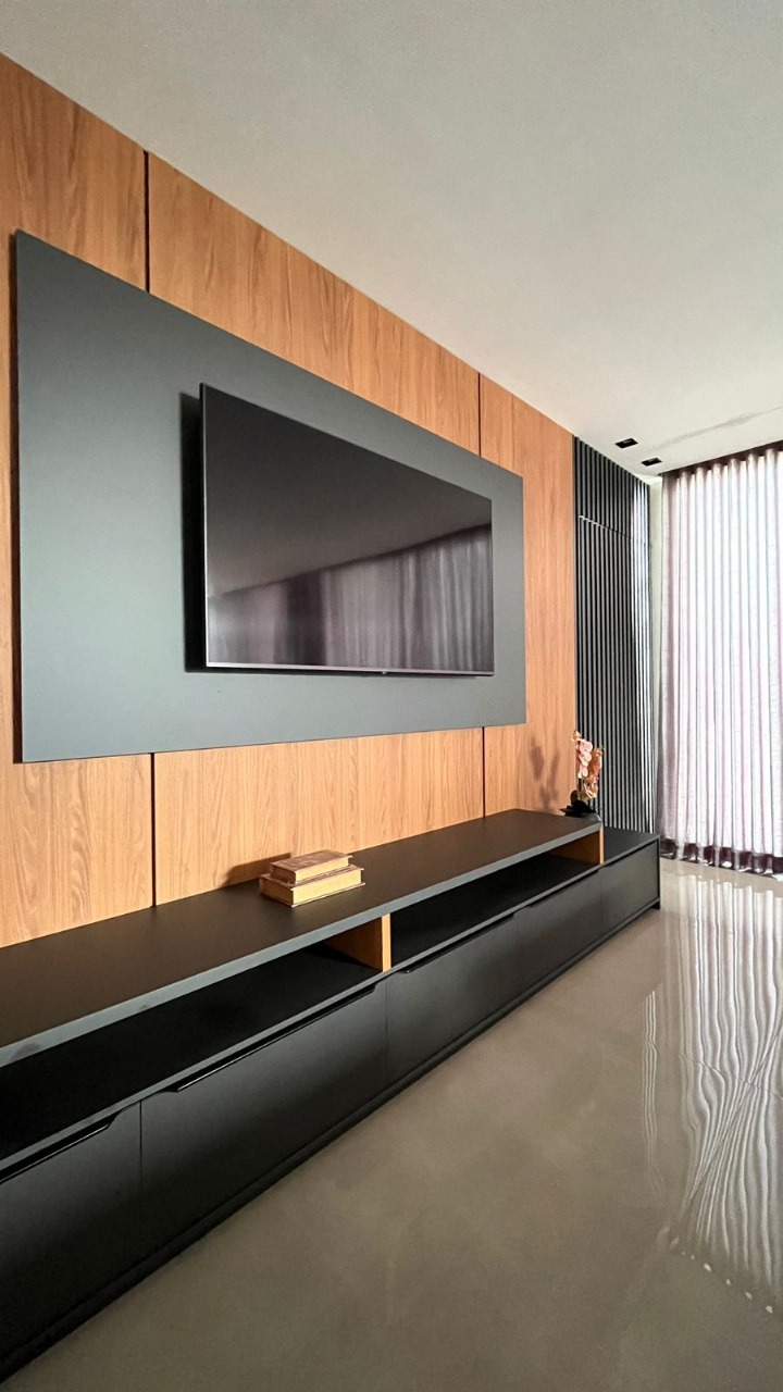 Sala de TV com painel de madeira quente