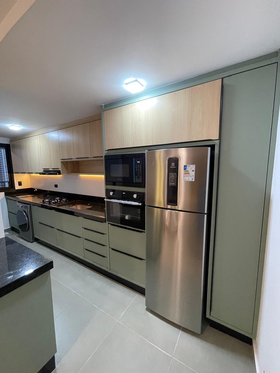 Cozinha verde sage com detalhes em inox